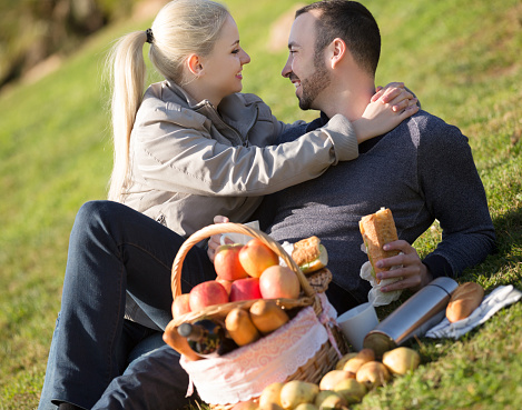 Couple lounging in sunny spring day at picnic outdoors