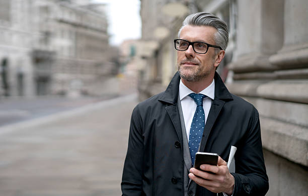 Business man using his cell phone on the street