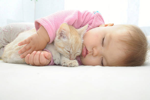 Baby and cat sleeping together