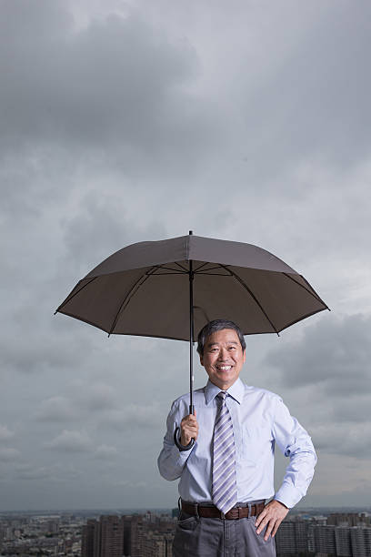 istock senior  businessman hold an umbrella 517928218