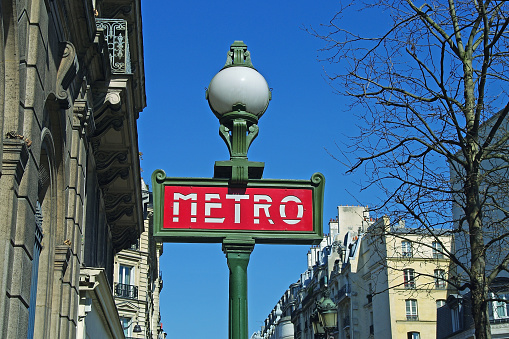 Paris, France - 1983: A vintage 1980's Fujifilm negative film scan of the classic ornate Paris Metro station sign and street lamp.