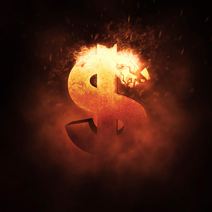 Dollar sign burning and breaks apart in a fire.