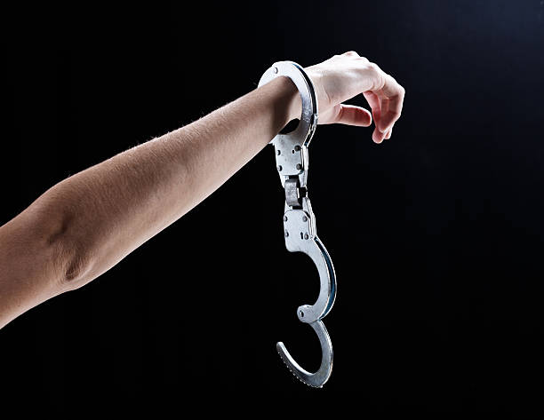 i'm бесплатно! женщина рука в одном, открытый handcuff. - bail стоковые фото и изображения