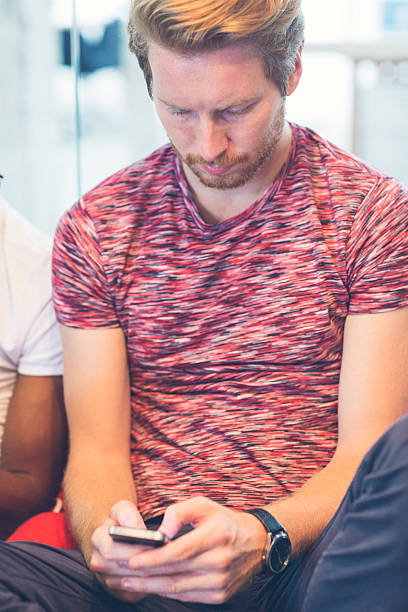istock Young Red Hair Man Typing on his smart phone. 517929729
