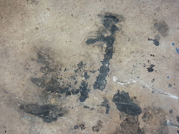 istock black oil stain on the cement floor texture background 517930096