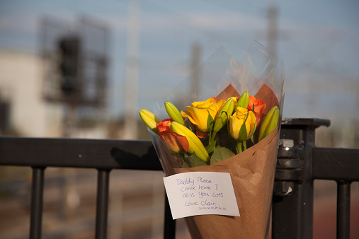 Flower left as a tribute at a railway station train passes flowers 
