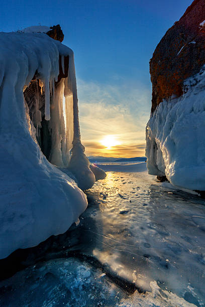Sunset over ice covered Baikal Sunset through big icycles on ice covered Baikal icecap photos stock pictures, royalty-free photos & images