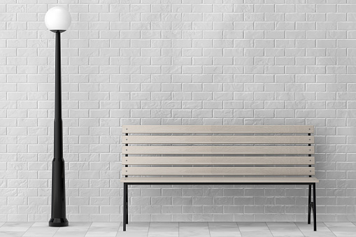 Wooden Bench and Street Lamp against white brick wall extreme closeup