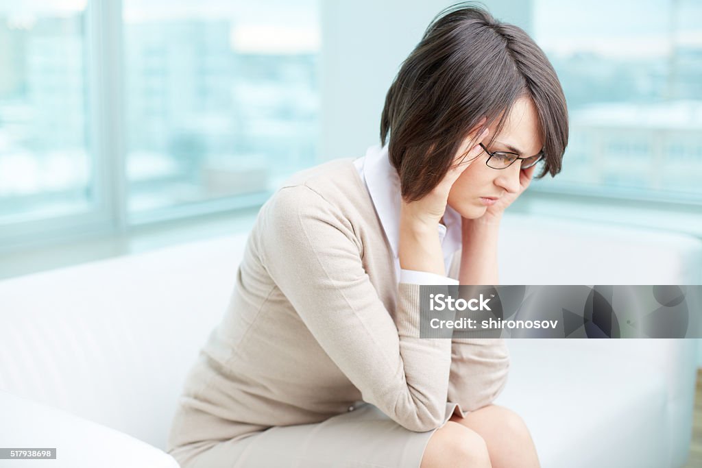 Rubbing temples Image of a frustrated or tired young brunette rubbing temples Adult Stock Photo