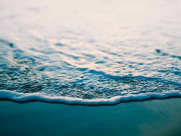 macro imagem tonalizada de oceano onda na praia - sea foam imagens e fotografias de stock