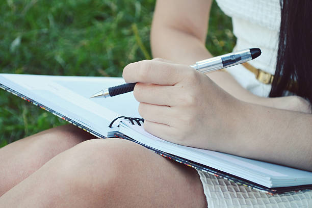 istock Woman with beautiful hands writing in her diary 517953521