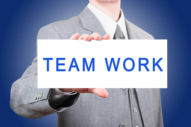 istock Businessman showing a large card with text Team Work 517954209
