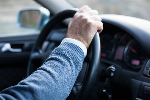 istock Man hand holding steering wheel in motion while drives. 517963072