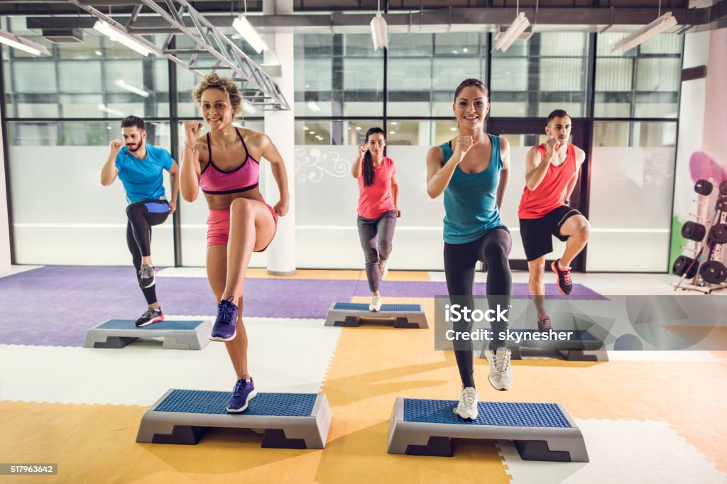 Gruppo di atletica persone esercizio passo aerobica in palestra. - Foto stock royalty-free di Step