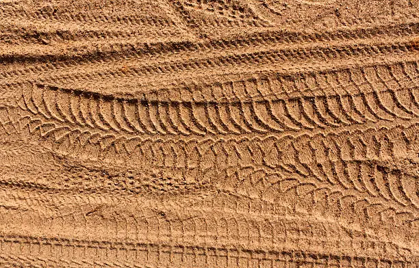 Photo of Tire tracks on sand.