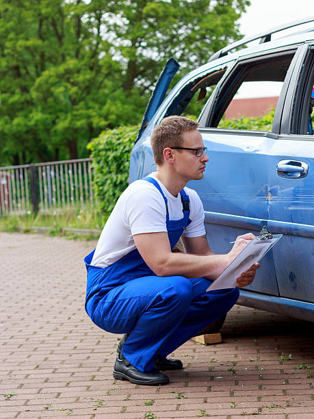 Mechanic checks damage to the vehicle Mechanic checks damage to the vehicle autounfall stock pictures, royalty-free photos & images