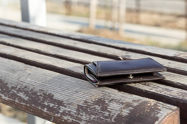 istock Lost brown leather wallet laying on bench 517971756