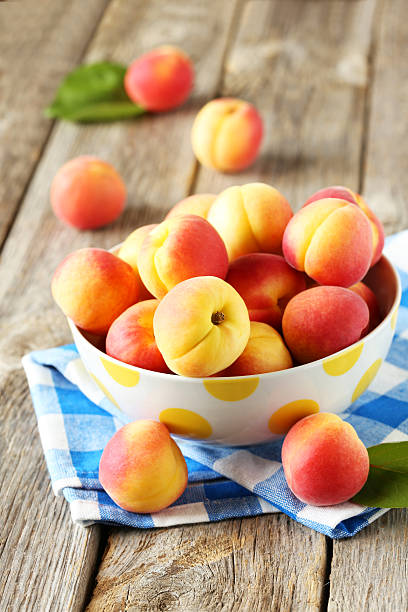 istock Fresh apricots in bowl on a grey wooden background 517972642