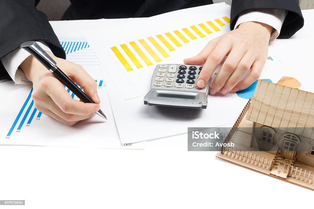 Businessman signs contract behind home architectural model Businessman signs contract behind home architectural model. Plan - Document Stock Photo