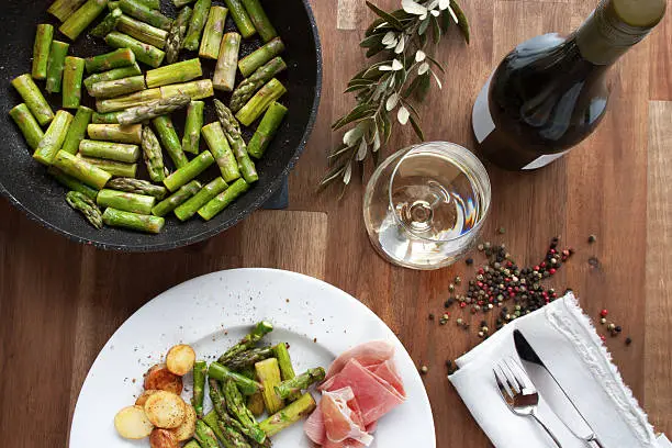 Green fried asparagus with ham and white wine