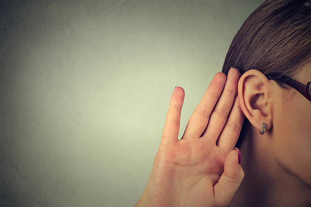 近くの女性が彼女の手でよく耳 リッスン - listening human ear communication human hand ストックフォトと画像