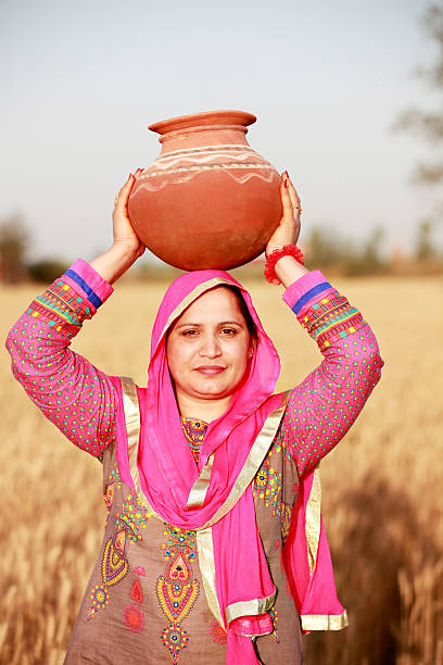 istock Farmer women carrying water pot on Her Head 517989962