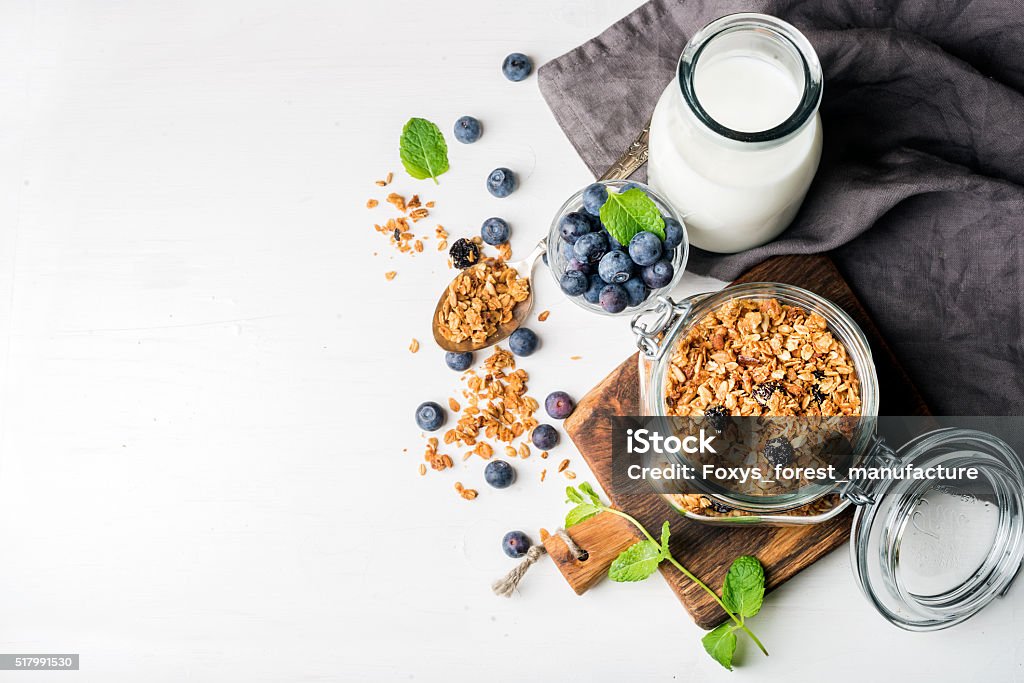 Prima colazione salutare ingrediens. Fatti in casa in un bel barattolo di vetro aperto muesli, latte - Foto stock royalty-free di Prima colazione