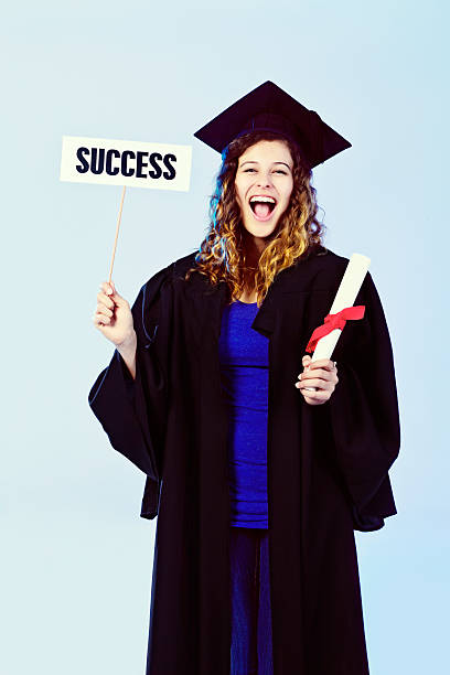 istock Cute, smiling young graduate holds sign 