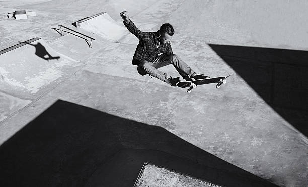 He's got skill A black and white shot of a skateboarder doing tricks at a skatepark x games stock pictures, royalty-free photos & images