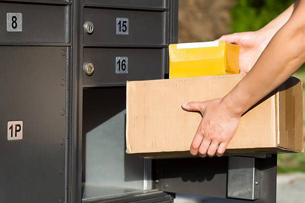 Packages being loaded into postal mailbox stock photo