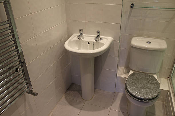 Image of modern, white tiled bathroom, pedestal sink, chrome radiator