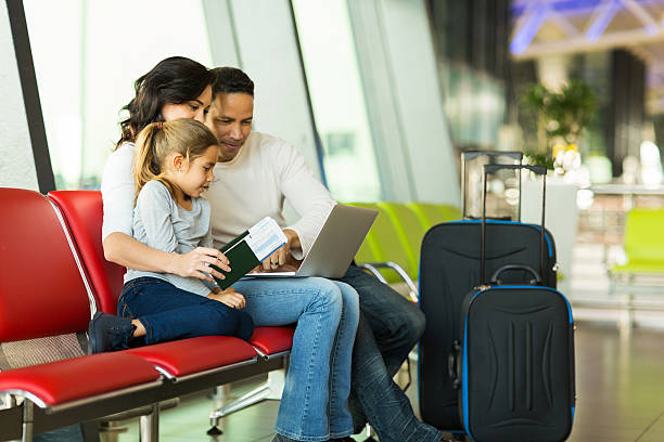 parents and daughter using laptop at airport