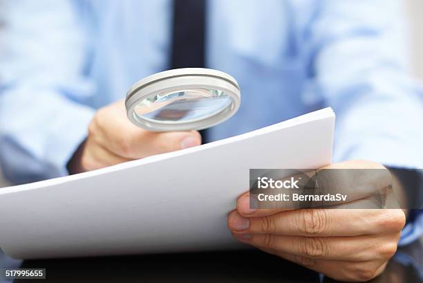 Businessman Looking Through A Magnifying Glass To Contract Stock Photo - Download Image Now