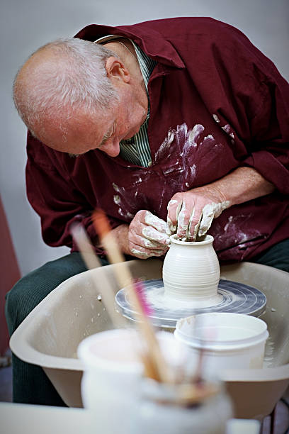 istock Senior potter working on pottery wheel 517996289
