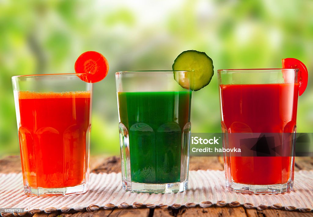 juice drink fresh juice, mix vegetable, tomato, cucumber and carrot drinks with nature green background. Blended Drink Stock Photo