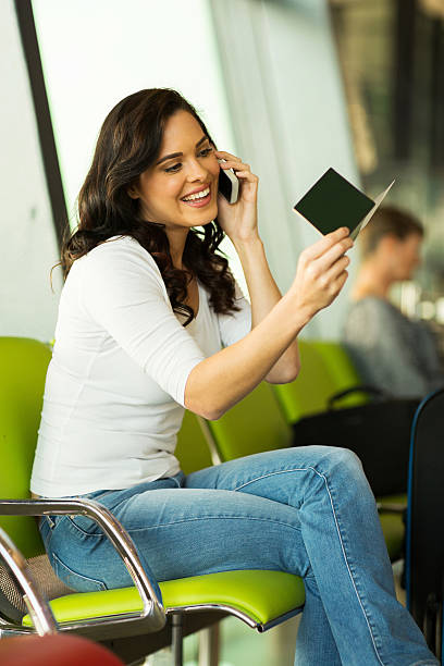 istock girl using cell phone at airport 517997473