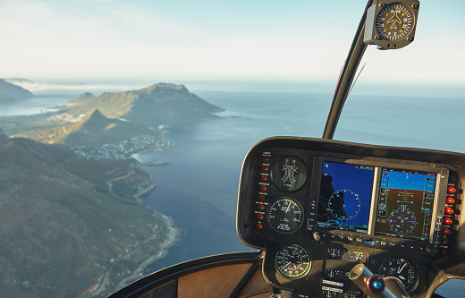 Aerial view from a helicopter cockpit flying over Cape town. Interior of helicopter cockpit with instruments panel.