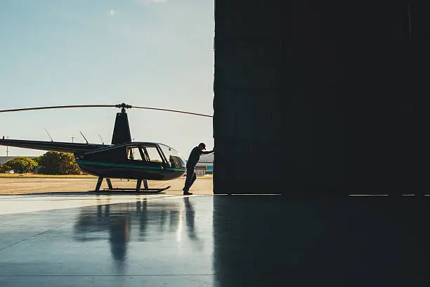 Photo of Pilot opening the helicopter hangar door.