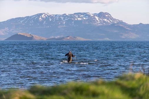 Candid view of fisherman in Thingvellir Lake, Iceland.