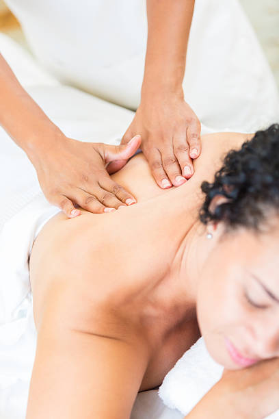 istock Professional massage therapist rubbing back of customer in spa 517998229
