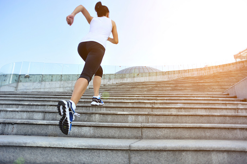 Runner athlete  running on stairs. woman fitness jogging workout wellness concept.