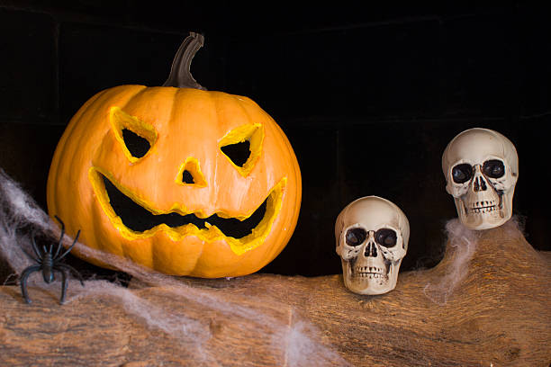 istock Halloween pumpkin and skull in a fireplace 517998813
