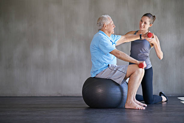 helfen patienten bleiben sie stark und gesund - senior adult exercising aging process instructor stock-fotos und bilder