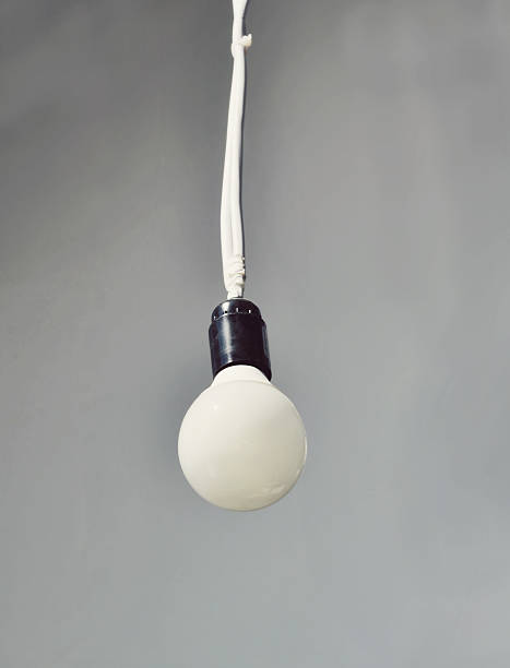 istock Lonely white bulb lamp hanging from the ceiling 517999935