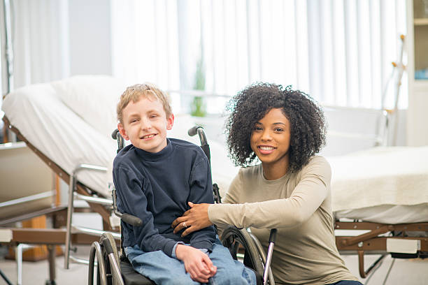 istock Caregiver Helping a Boy into a Wheelchair 518000548