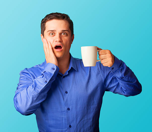 istock Surprised man in shirt with cup on blue background. 518012877