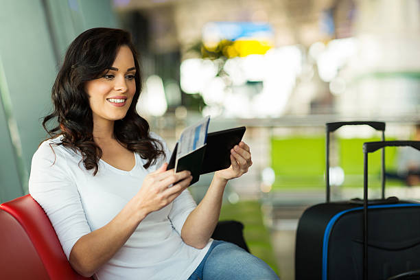 istock young woman reading her email on tablet computer at airport 518014153