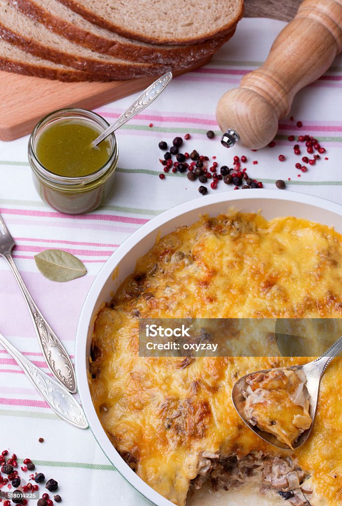 mushrooms and cabbage casserole in frying pan with bread, pesto, casserole with mushrooms and cabbage in frying pan with fresh bread, pesto, pepper and pepper mill on linen tablecloth Backgrounds Stock Photo