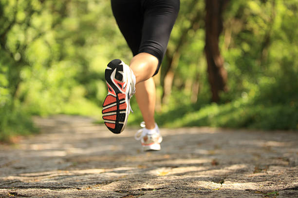 бегун спортсмен legs running on forest trail. - running legs стоковые фото и изображения