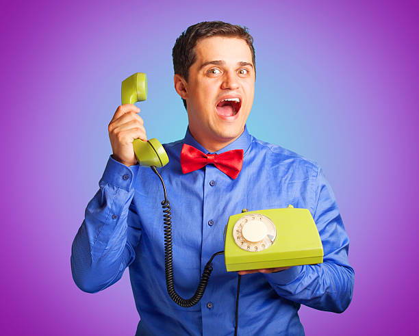 istock Surprised man in shirt with telephone on blue background. 518015735